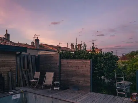 Bordeaux, 2022. Deck chairs on a wooden terrace at dusk.