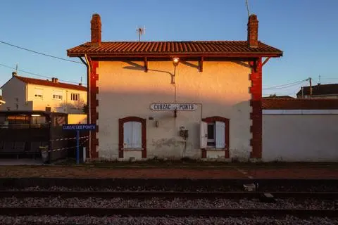 Cubzac-les-Ponts, 2022. The small station building at sunset, across the tracks.