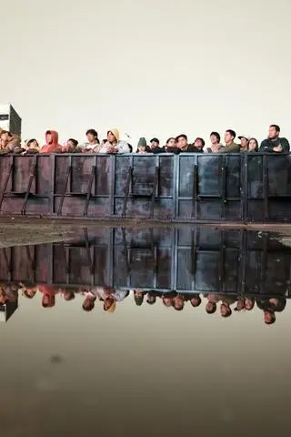 Fiestas de Quito, 2025. A crowd behind a barrier, reflected in the water.