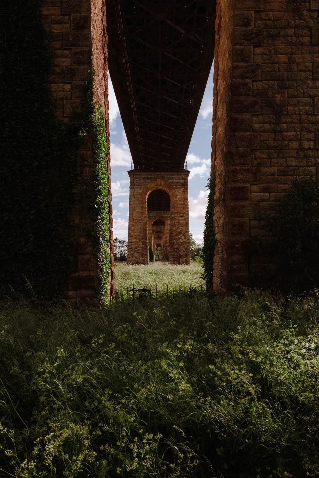 Underneath a tall brick bridge