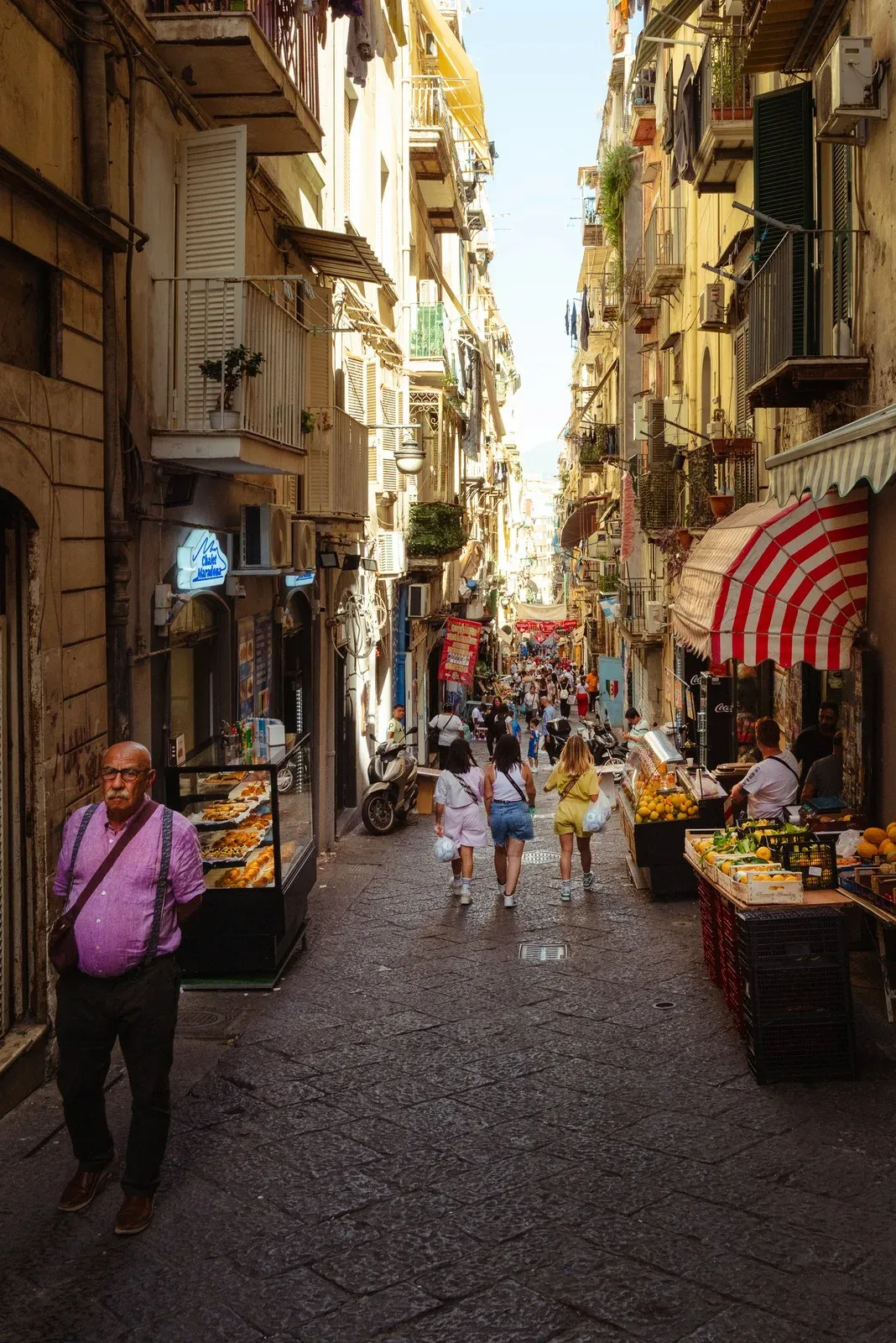A narrow street in Naples with market stalls