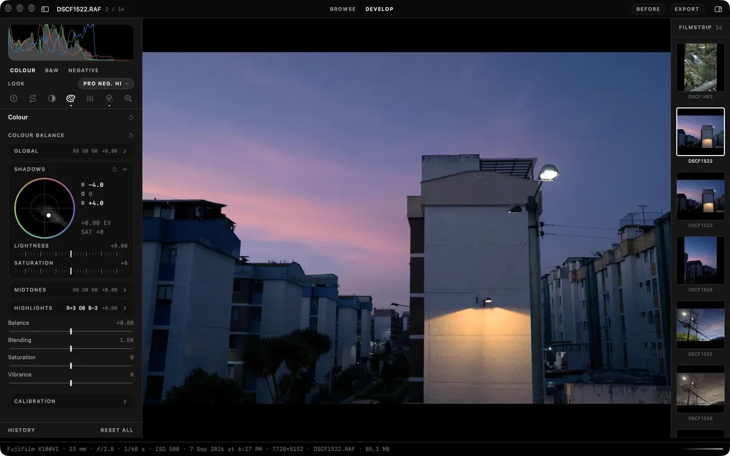 Develop on the Colour tab, dark appearance: the seven tool tabs, the Shadows wheel open and the slider rows below, over a dusk street